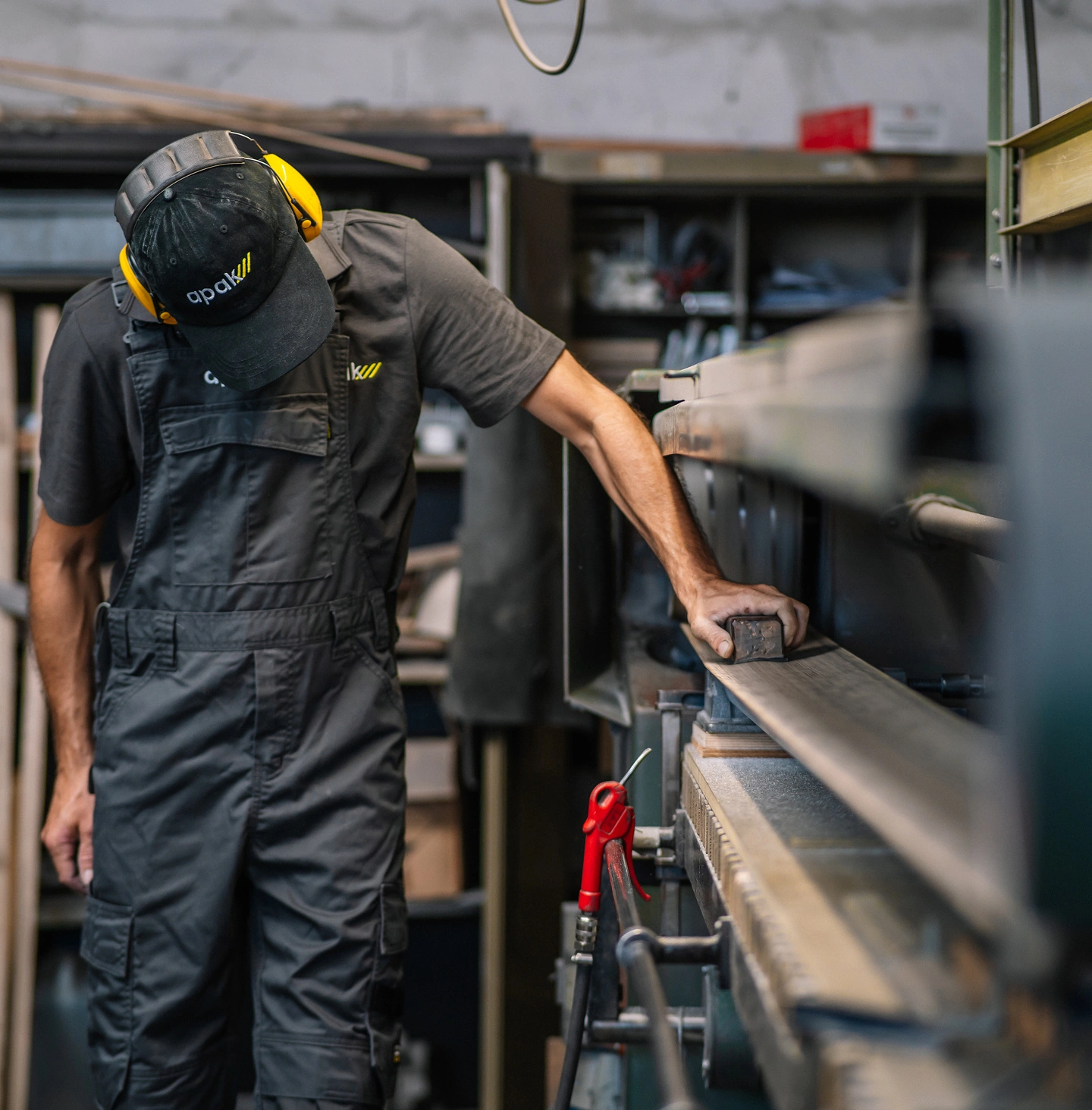 Een APAK-medewerker werkt een metalen profiel met de hand af in het atelier.