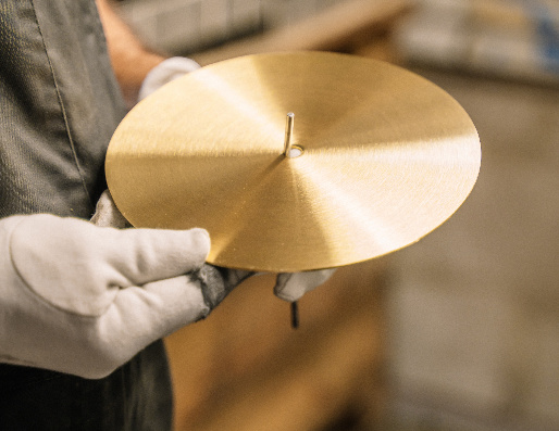 Een ronde messing schijf met een satijnafwerking.